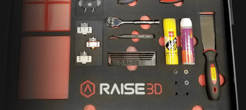 Pannello attrezzi con logo Raise3D e strumenti per stampa 3D, area di lavoro in metallo nero con inserti arancioni, legata a Raise3D Pro3 PLUS HS