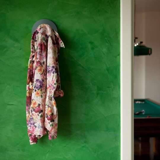 Un appendiabiti grigio con tessuto floreale su sfondo verde, in linea con l’estetica naturale del PLA Effetto Pietra di Eumaker